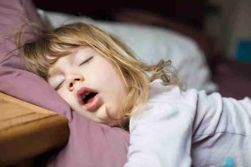 Young child sleeping with mouth open, showing a common airway issue like mouth breathing.