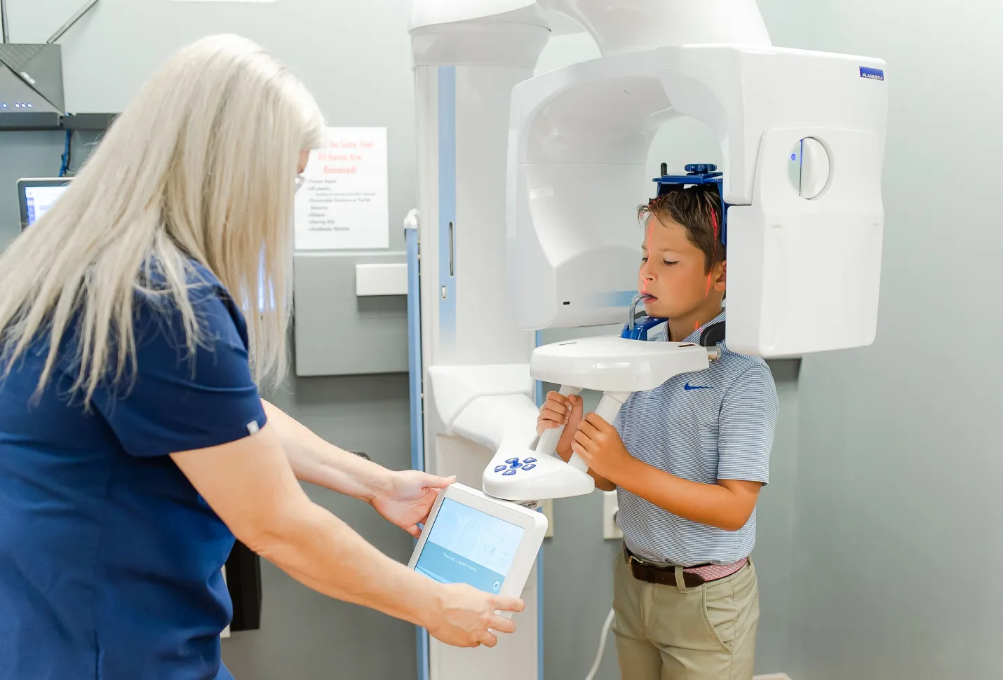Boy undergoing a dental 3D scan with a technician assisting during an airway dentistry evaluation.