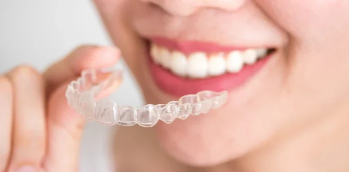 Invisalign candidate signs for clear aligners in College Station