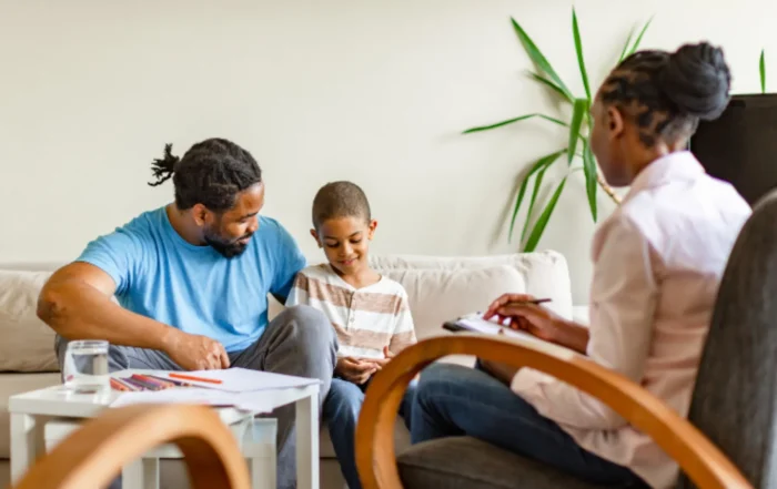 Myofunctional therapy for kids. Father and son meeting with a therapist to discuss oral habits and airway health.