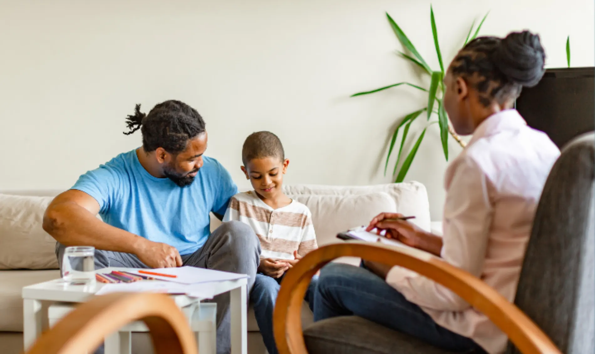 Myofunctional therapy for kids. Father and son meeting with a therapist to discuss oral habits and airway health.